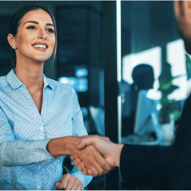 Social Selling mit LinkedIn I Anne Meinhardt Dekoratives Bild zum Bonus-Modul "Social Selling mit LinkedIn" von Marketing-Trainerin und LinkedIn-Expertin Anne Meinhardt aus Dresden. Zu sehen ist ein Foto von einer Frau mit einer blauen Bluse, welche freundlich lächelnd einem Mann die Hand reicht.