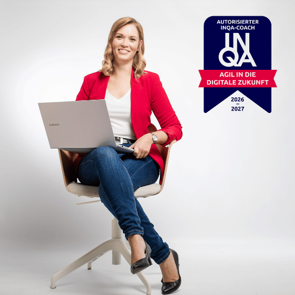 Anne Meinhardt, Marketing-Expertin aus Dresden, sitzt auf einem Stuhl mit Laptop auf dem Schoß und lächelt in die Kamera. Oben rechts ist das Badge als autorisierter INQA-Coach zu sehen.